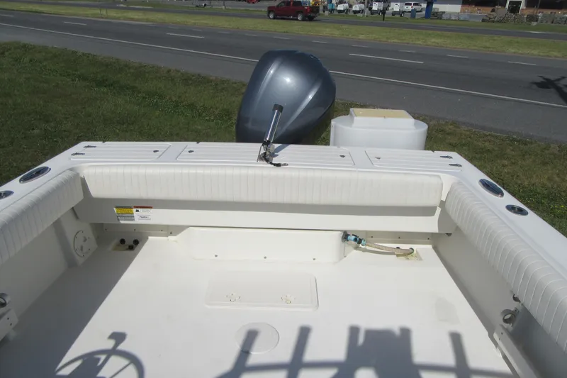 Slide: The Image of 2013 Parker 2320 SL Sport Cabin boat interior with outboard motor, parked near a road. - 14