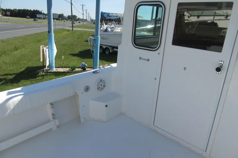 Slide: The Image of 2013 Parker 2320 SL Sport Cabin boat interior with door and seating area. - 16