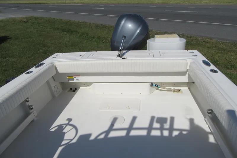 Slide: The Image of 2013 Parker 2320 SL Sport Cabin boat interior with outboard motor, parked near a road. - 19