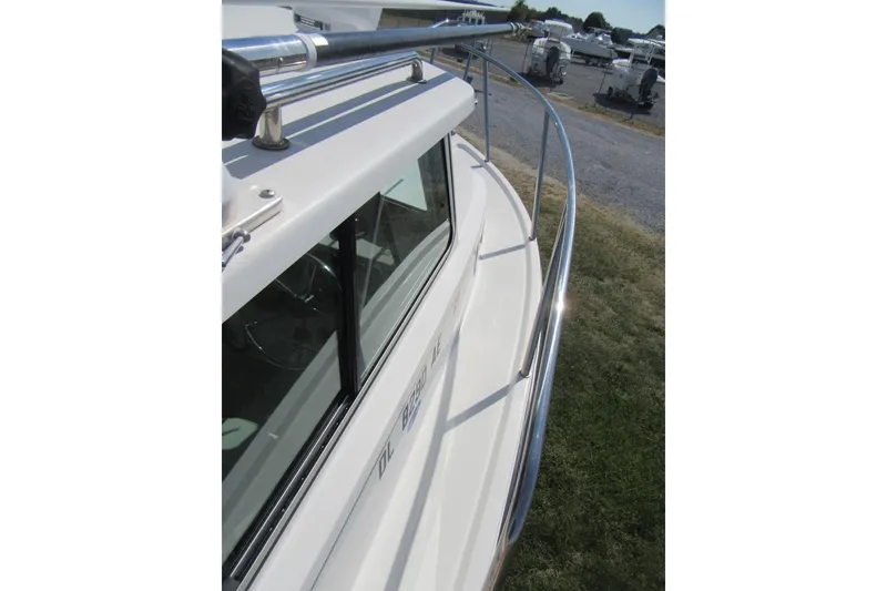 Slide: The Image of 2013 Parker 2320 SL Sport Cabin boat with stainless steel railing and cabin window. - 26
