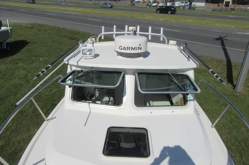 Slide: The Image of 2013 Parker 2320 SL Sport Cabin boat with Garmin radar, parked near a road. - 28