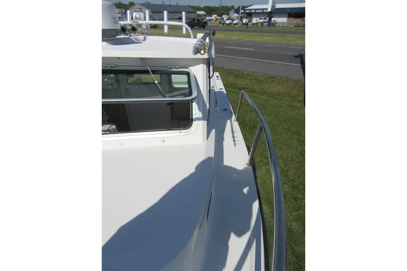 Slide: The Image of 2013 Parker 2320 SL Sport Cabin boat, side view with railing and cabin window. - 29
