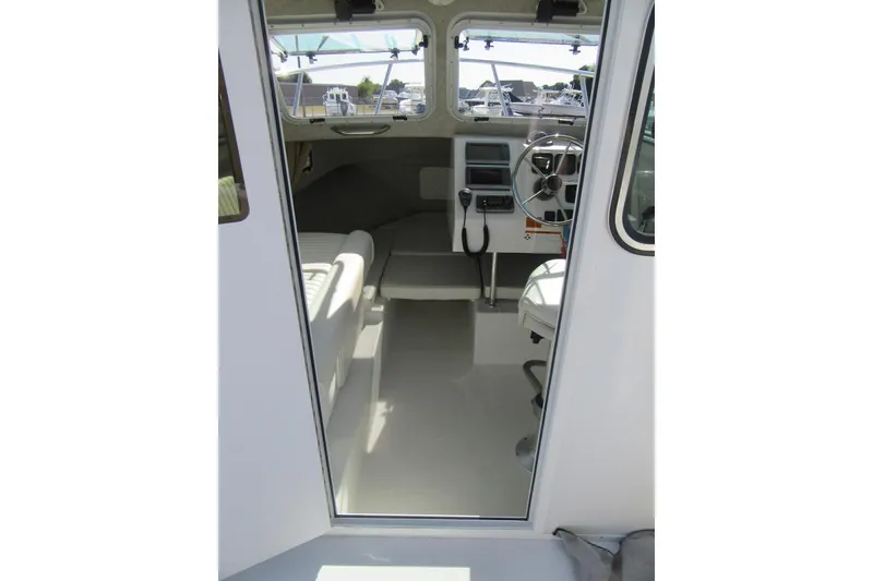 Slide: The Image of Interior view of 2013 Parker 2320 SL Sport Cabin boat, featuring steering wheel and seating. - 31