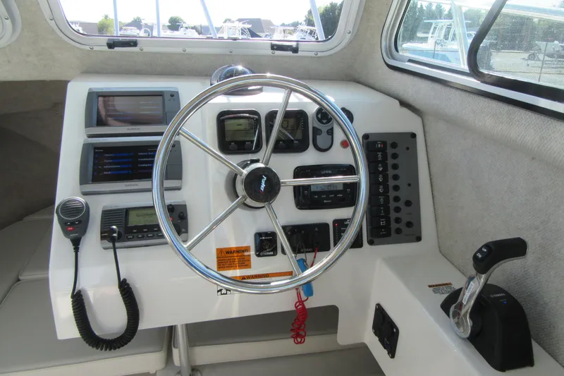 Slide: The Image of 2013 Parker 2320 SL Sport Cabin boat dashboard with steering wheel and navigation controls. - 35