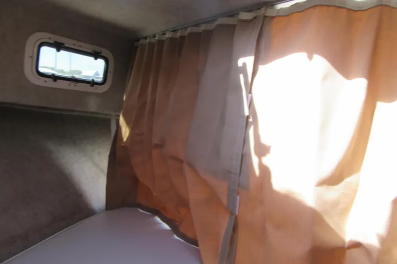 Slide: The Image of Interior cabin view of a 2013 Parker 2320 SL Sport Cabin with curtains and a window. - 49