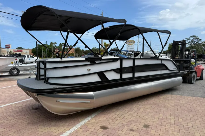 Slide: The Image of 2026 Evotti 523CS pontoon boat with black canopy, parked on brick pavement. - 3