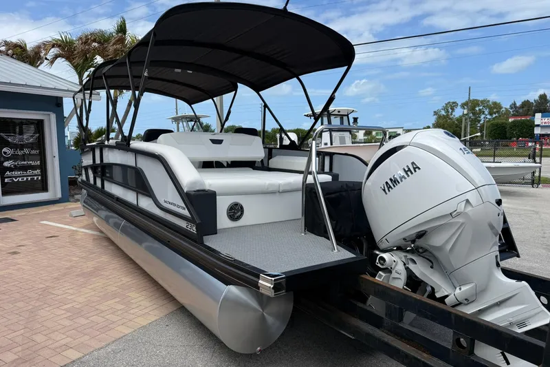 Slide: The Image of 2026 Evotti 523CS pontoon boat with Yamaha engine, parked near a dealership. - 4