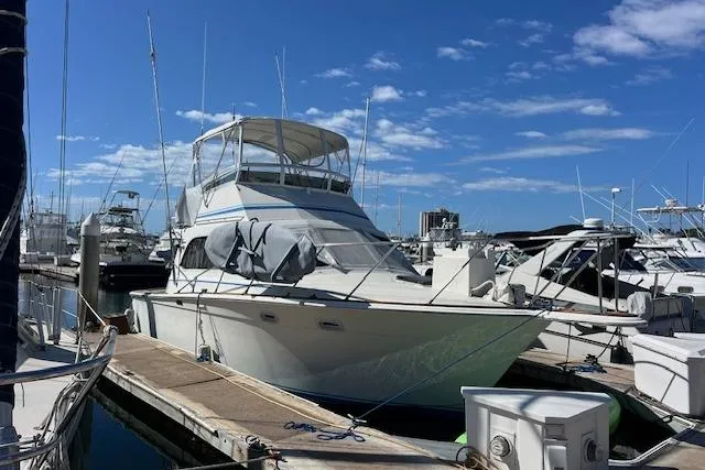 The Image of 1985 Egg Harbor 33 Convertible yacht docked at marina under clear blue sky. - 0