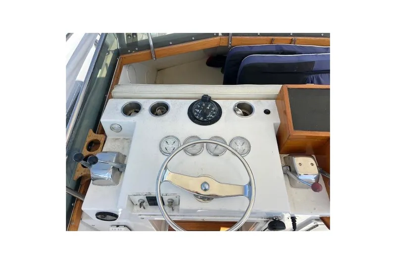 Slide: The Image of 1985 Egg Harbor 33 Convertible boat dashboard with steering wheel and gauges. - 12