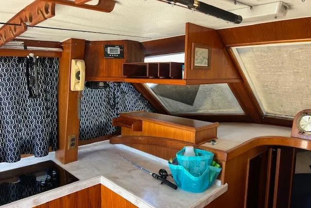 Slide: The Image of Interior of 1985 Egg Harbor 33 Convertible boat with wood accents and fishing gear. - 19