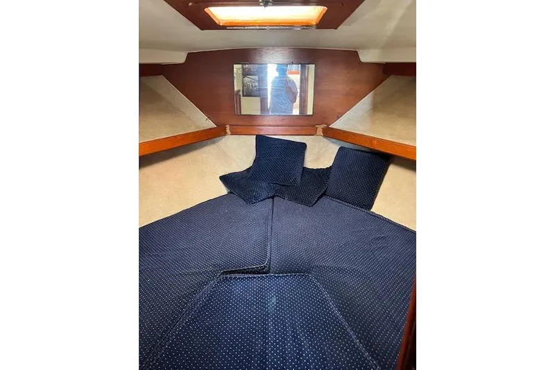 Slide: The Image of Cozy cabin interior of 1985 Egg Harbor 33 Convertible with blue bedding and wooden accents. - 25