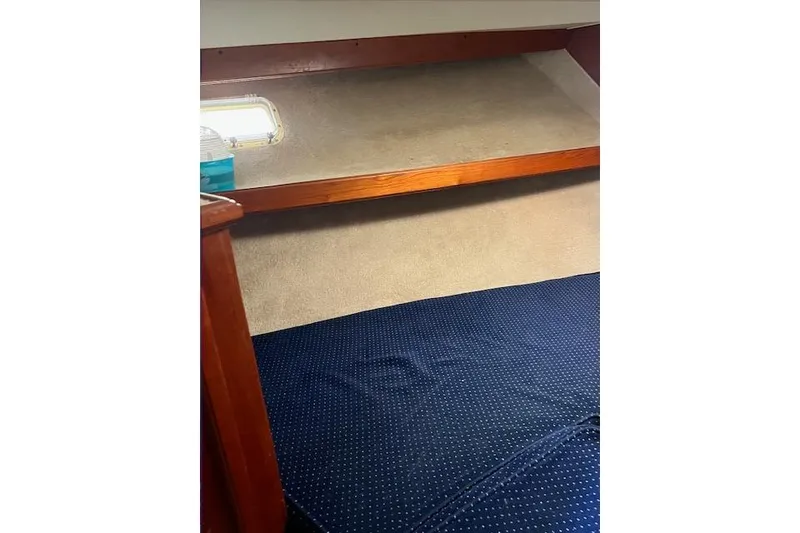 Slide: The Image of Interior cabin of 1985 Egg Harbor 33 Convertible with blue bedding and wooden accents. - 26