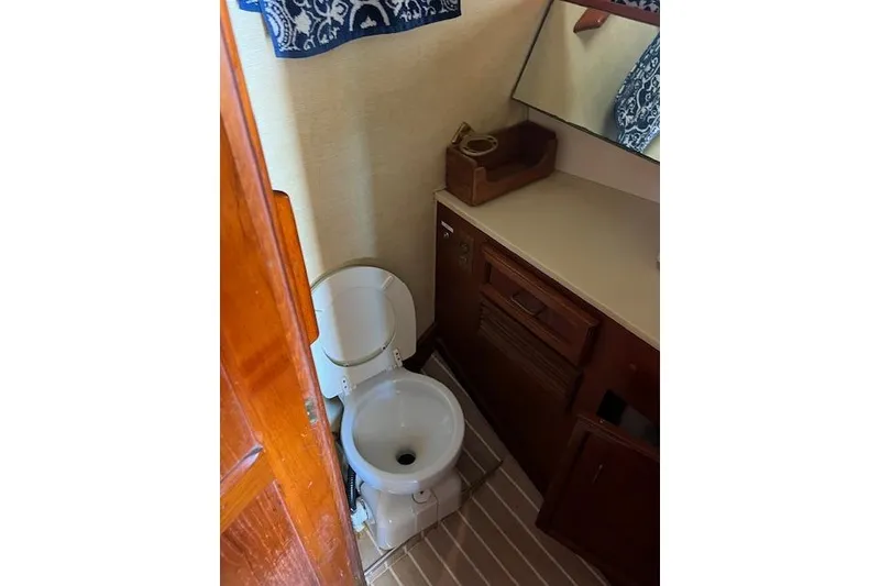 Slide: The Image of Bathroom interior of 1985 Egg Harbor 33 Convertible yacht, featuring toilet and wooden cabinetry. - 28
