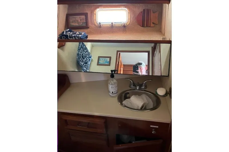 Slide: The Image of 1985 Egg Harbor 33 Convertible yacht bathroom with sink, mirror, and nautical decor. - 29
