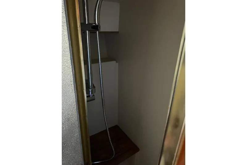 Slide: The Image of Shower area inside 1985 Egg Harbor 33 Convertible boat, featuring a handheld showerhead. - 30