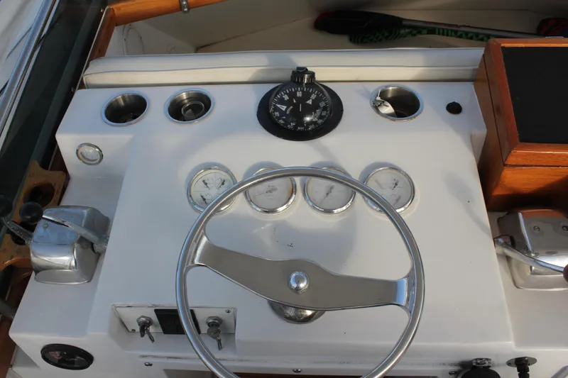 Slide: The Image of 1985 Egg Harbor 33 Convertible boat dashboard with steering wheel and gauges. - 33