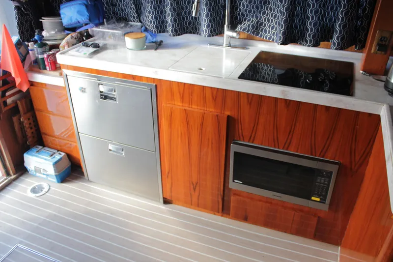 Slide: The Image of Galley kitchen in 1985 Egg Harbor 33 Convertible boat with wood cabinetry and modern appliances. - 37