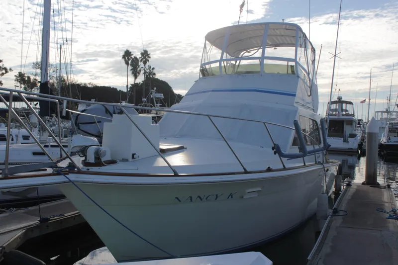 Slide: The Image of 1985 Egg Harbor 33 Convertible yacht docked at marina under cloudy sky. - 4