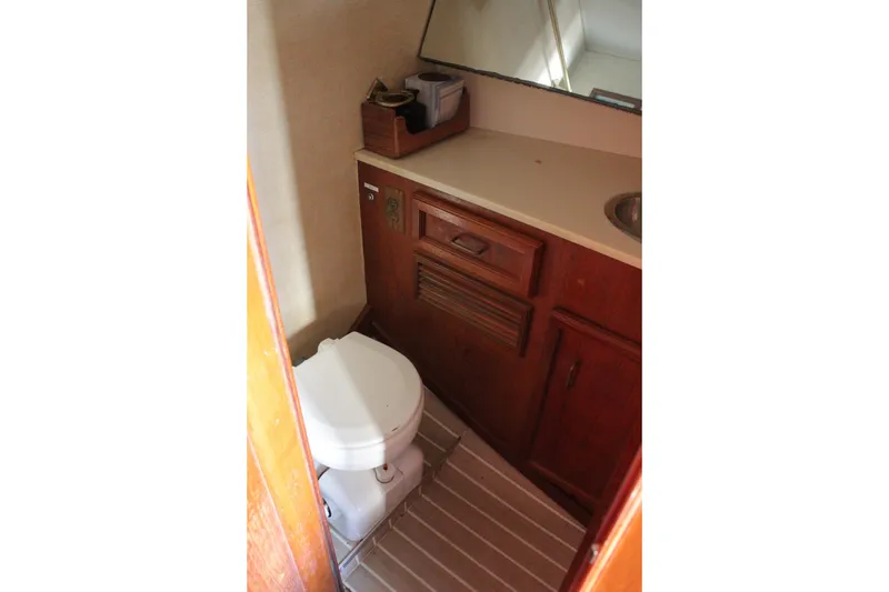 Slide: The Image of 1985 Egg Harbor 33 Convertible boat bathroom with wooden cabinetry and compact toilet. - 40