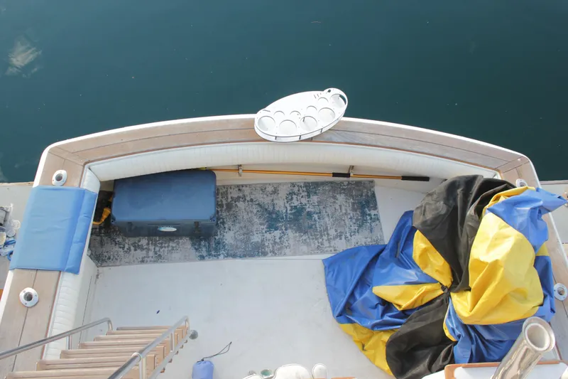 Slide: The Image of 1985 Egg Harbor 33 Convertible boat deck with seating, storage, and colorful tarp. - 42