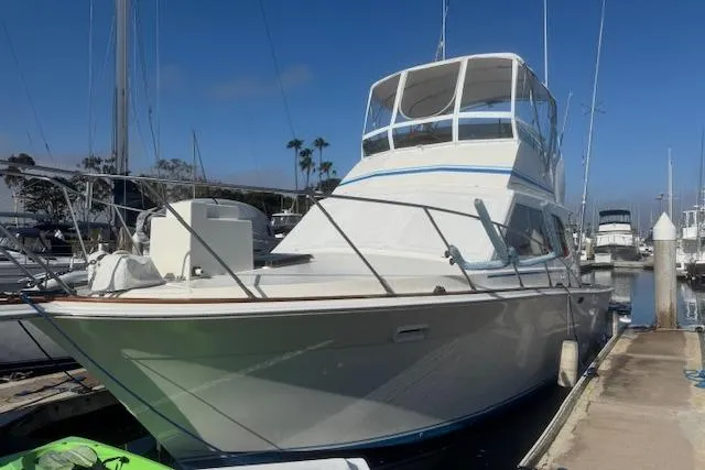 Slide: The Image of 1985 Egg Harbor 33 Convertible yacht docked at marina under clear blue sky. - 45