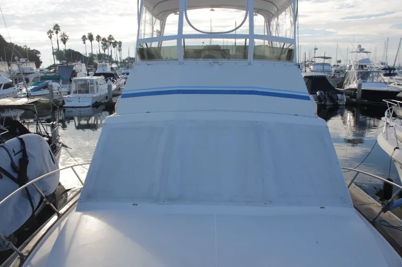 Slide: The Image of 1985 Egg Harbor 33 Convertible yacht docked in a marina, surrounded by other boats. - 5