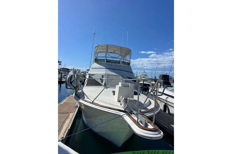 Slide: The Image of 1985 Egg Harbor 33 Convertible yacht docked at marina under clear blue sky. - 8