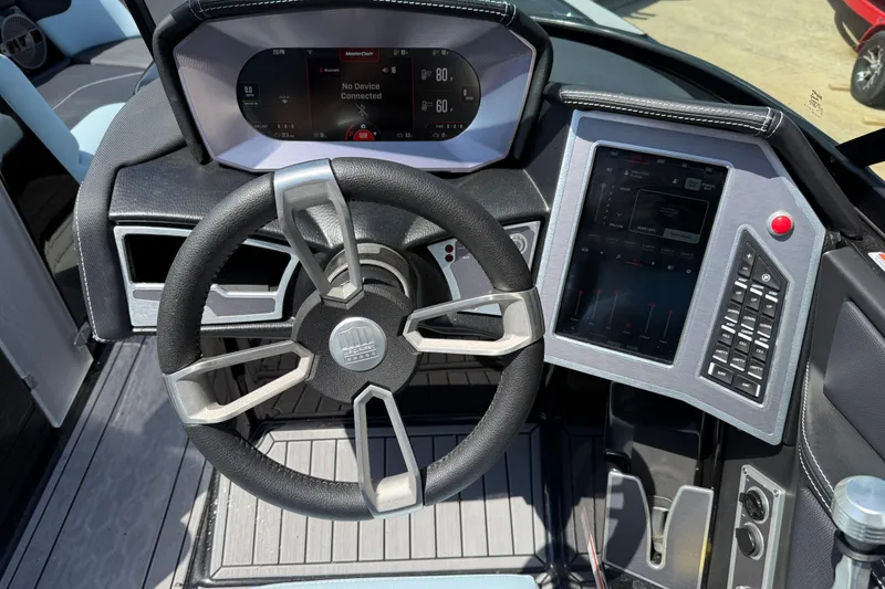 Slide: The Image of 2022 MasterCraft XT24 dashboard with steering wheel and digital controls. - 10