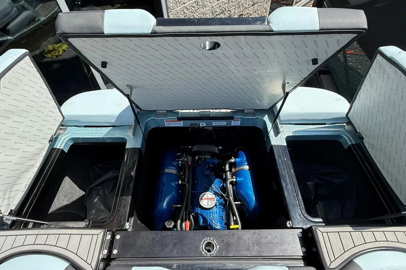 Slide: The Image of Open engine compartment of 2022 MasterCraft XT24 boat, showcasing blue engine components. - 26