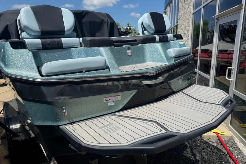 Slide: The Image of 2022 MasterCraft XT24 boat with sleek design and comfortable seating, displayed outdoors. - 34