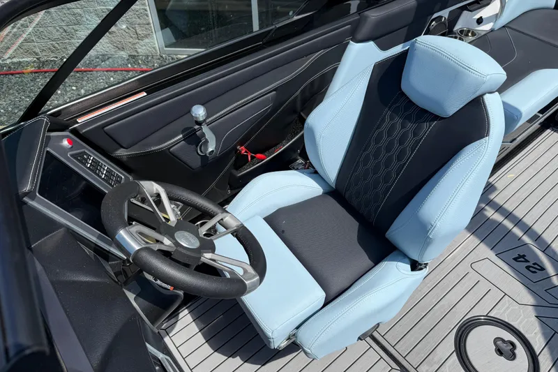 Slide: The Image of 2022 MasterCraft XT24 boat interior with sleek steering wheel and comfortable seating. - 7