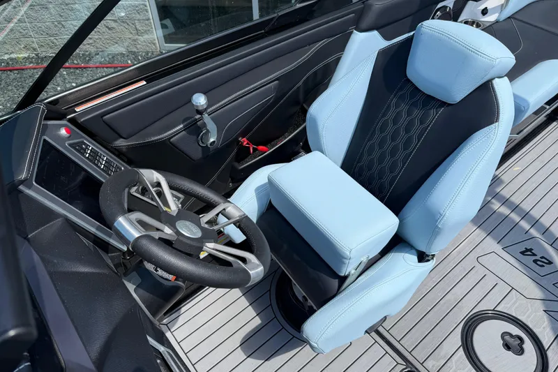 Slide: The Image of 2022 MasterCraft XT24 boat interior with sleek steering wheel and luxurious seating. - 8
