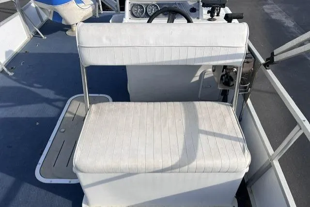Slide: The Image of 1995 Playbuoy 20 Grand Tahoe Fisher boat interior with white seating and steering console. - 10