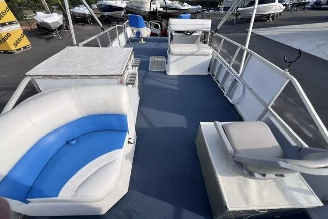 Slide: The Image of 1995 Playbuoy 20 Grand Tahoe Fisher pontoon boat with blue and white seating, docked outdoors. - 12