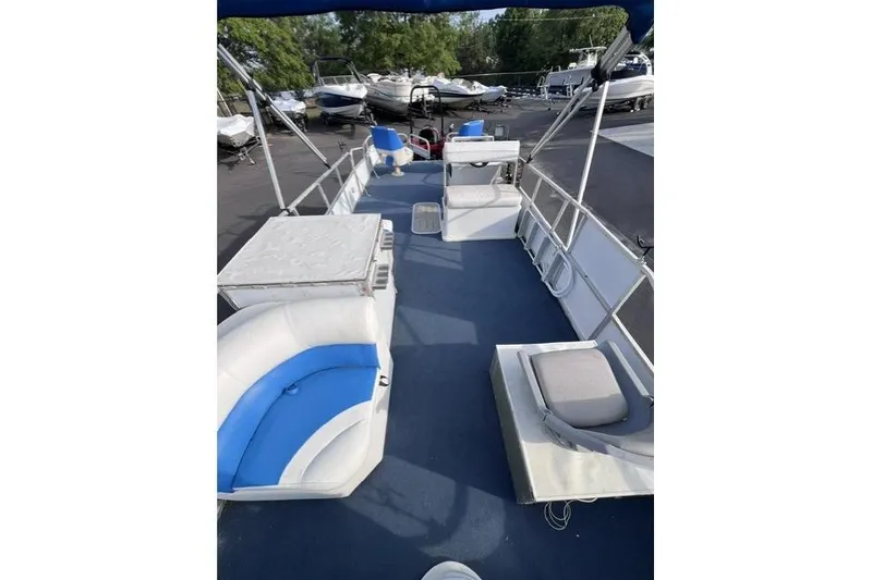 Slide: The Image of 1995 Playbuoy 20 Grand Tahoe Fisher pontoon boat with blue and white seating, docked outdoors. - 13