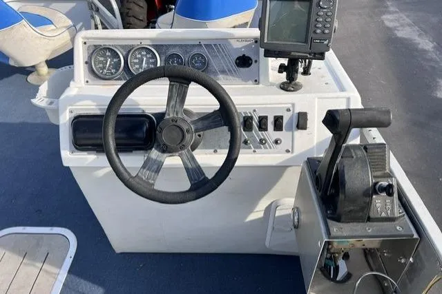 Slide: The Image of 1995 Playbuoy 20 Grand Tahoe Fisher boat dashboard with steering wheel and controls. - 9