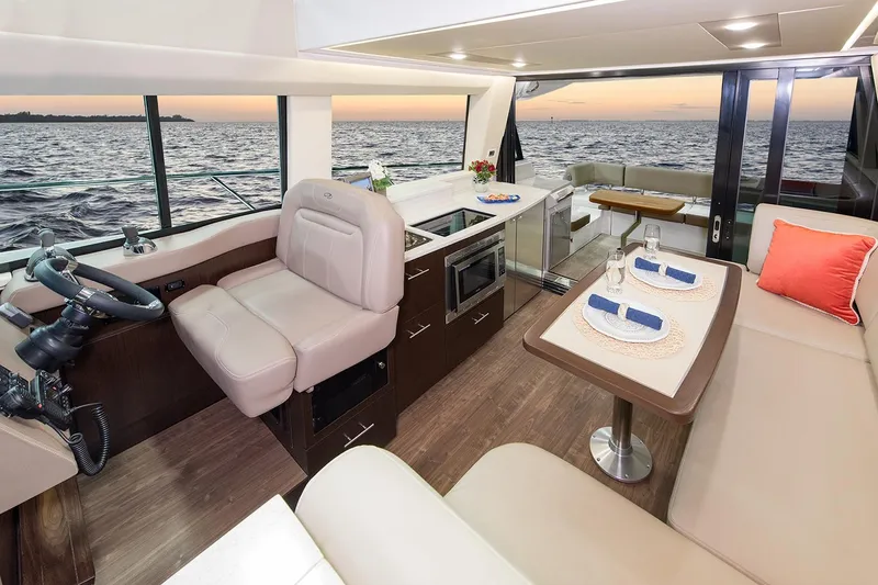 Slide: The Image of Curved window view from 2019 Regal 42 Grande Coupe yacht, reflecting cloudy sky. - 22