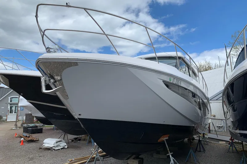 Slide: The Image of 2019 Regal 42 Grande Coupe yacht on dry dock under a cloudy sky. - 42