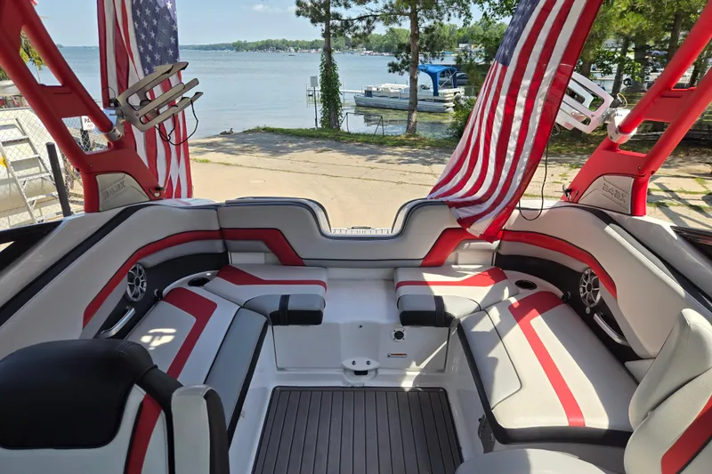 Slide: The Image of 2018 Yamaha Boats 242X interior with red accents, American flags, and lake view. - 19