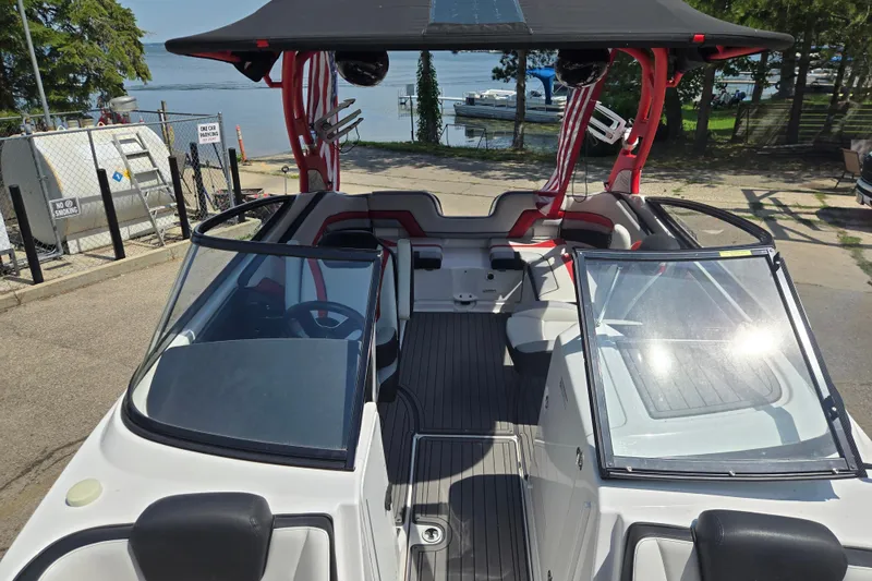 Slide: The Image of 2018 Yamaha Boats 242X interior with open cockpit, sleek design, and waterfront view. - 7