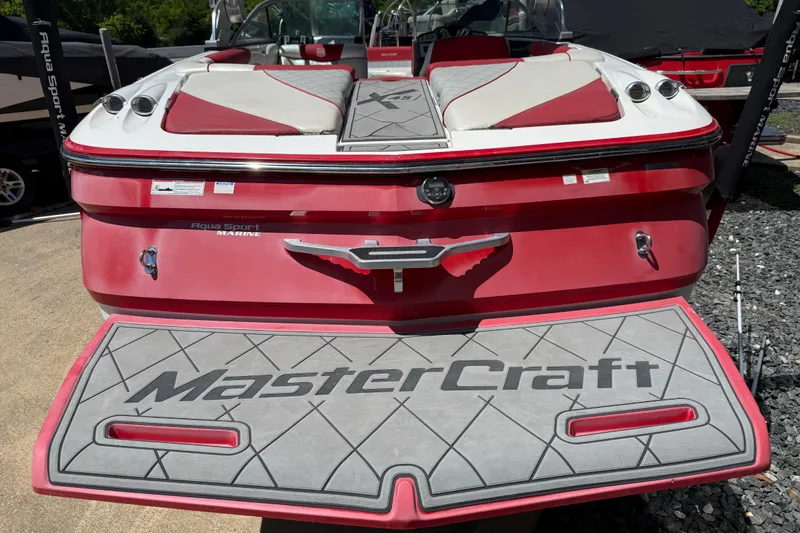 Slide: The Image of Red 2013 MasterCraft X-45 boat with custom deck and seating, parked outdoors. - 22