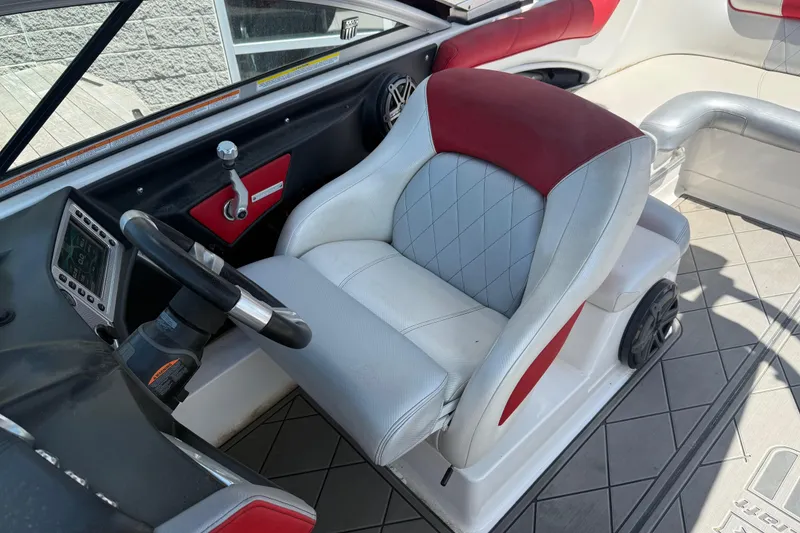 Slide: The Image of Captain's seat and dashboard of a 2013 MasterCraft X-45 boat, featuring red and gray upholstery. - 6