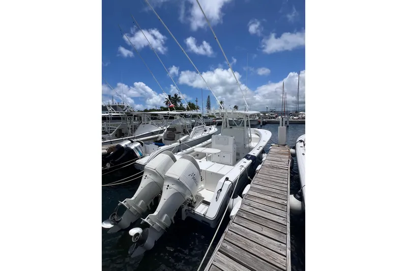 Slide: The Image of 2004 Regulator 32 Center Console boat docked at marina under clear skies. - 12