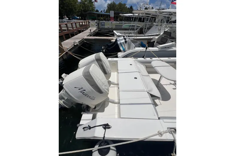 Slide: The Image of 2004 Regulator 32 Center Console boat docked under a partly cloudy sky. - 13