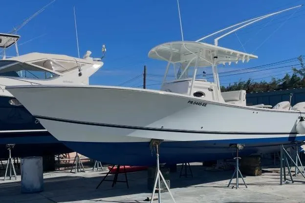 Slide: The Image of 2004 Regulator 32 Center Console boat docked under a partly cloudy sky. - 4
