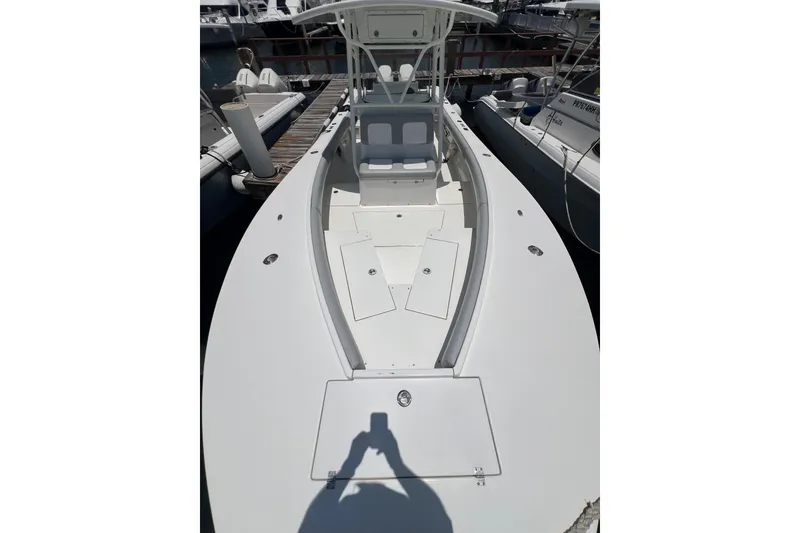 Slide: The Image of 2004 Regulator 32 Center Console boat docked at marina under clear blue sky. - 5