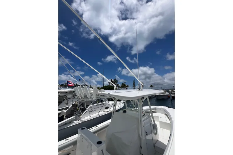 Slide: The Image of 2004 Regulator 32 Center Console boat docked at marina under blue sky. - 7