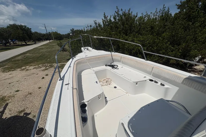 Slide: The Image of 1999 Boston Whaler 260 Outrage boat deck, featuring spacious seating and railing, parked outdoors. - 10