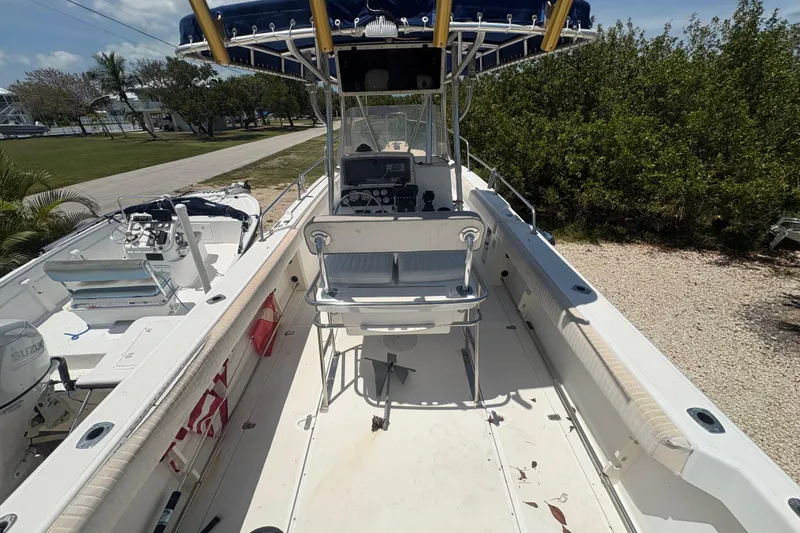 Slide: The Image of 1999 Boston Whaler 260 Outrage boat with spacious deck and canopy, parked outdoors. - 7