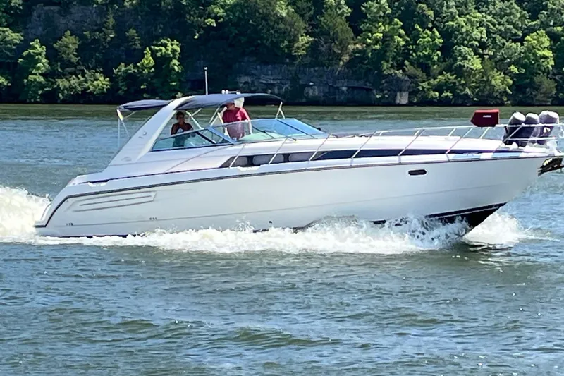 The Image of 1997 Avanti 4085 Sunbridge cruising on a scenic river with lush green trees. - 0